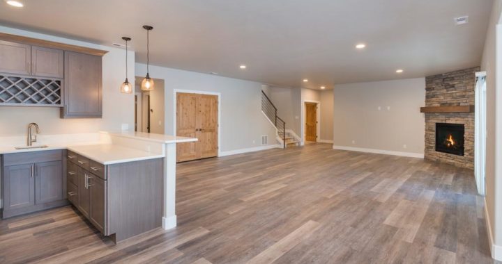 Basement Room with Built-in Wet Bar, a laminate flooring, a fireplace in one corner, and a kitchenette