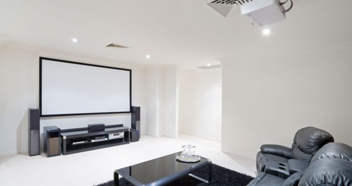 Modern bright home theater Room with black leather recliner chairs
